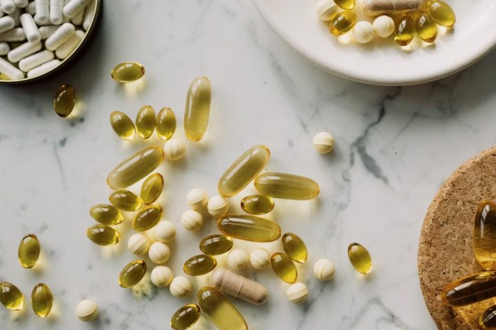 A collection of supplements and pills scattered on a marble surface, showcasing healthcare essentials.